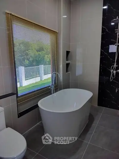 Luxurious bathroom with modern freestanding bathtub and elegant tile design.