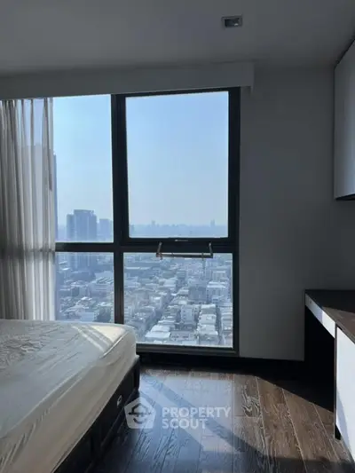 Modern bedroom with stunning city view from large window, featuring sleek wooden flooring and minimalist design.