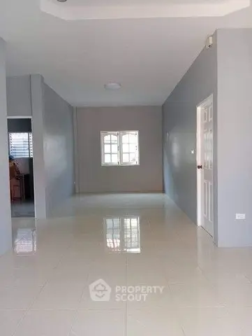 Spacious empty room with glossy tiled floor and neutral walls