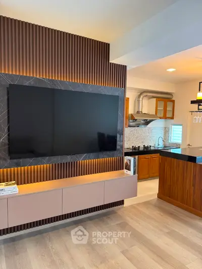 Modern living room with large TV and stylish open kitchen design