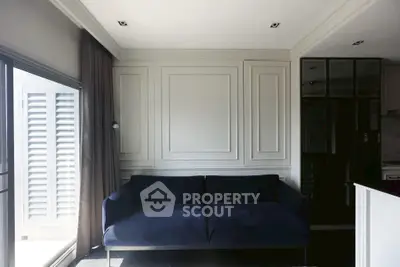 Modern living room with elegant dark sofa and stylish paneling