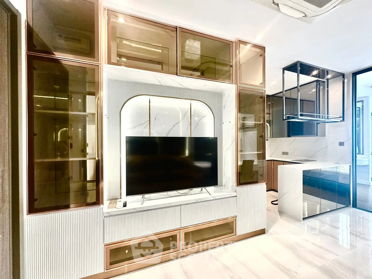 Luxurious modern living room with sleek built-in TV unit and elegant glass cabinets.