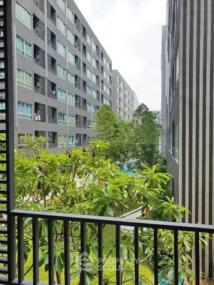 Modern apartment complex with lush greenery and spacious balconies.