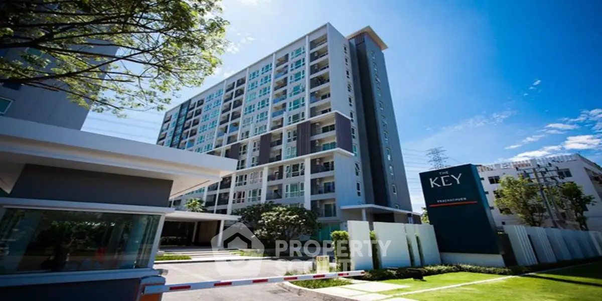 Modern condominium building with lush landscaping and clear blue sky.