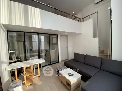 Modern loft apartment with mezzanine, open living area, and sleek kitchen design.
