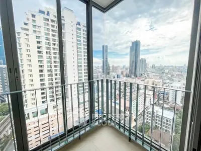 Stunning city view from modern high-rise balcony with glass railing.