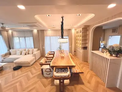Luxurious open-plan living and dining area with elegant wooden furniture and ambient lighting.