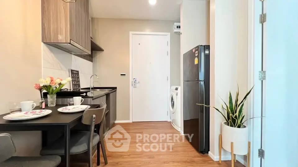 Modern kitchen with dining area, featuring sleek appliances and stylish decor in a cozy apartment setting.