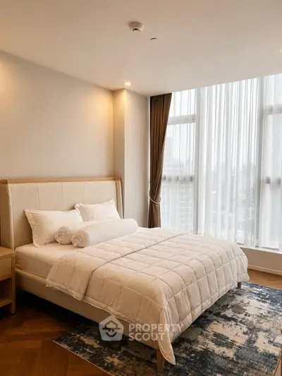 Luxurious bedroom with large windows and elegant decor in a modern apartment.