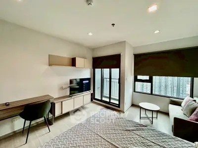 Modern studio apartment with balcony and city view, featuring stylish furniture and natural light.