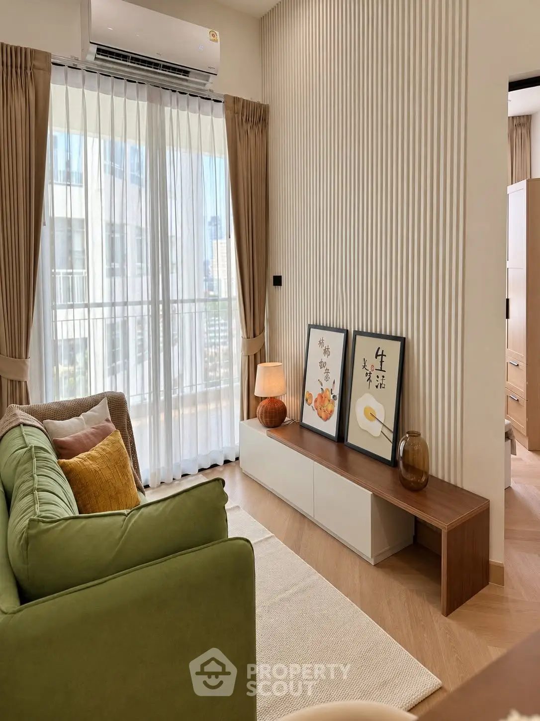 Modern living room with green sofa, stylish decor, and large window with city view.