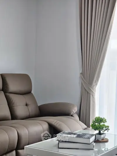 Cozy living room with plush sofa and elegant curtains, perfect for relaxation.