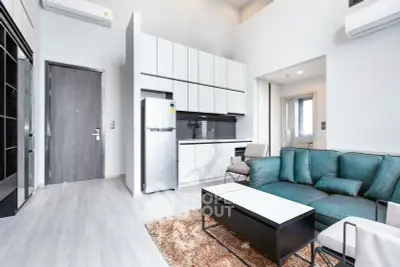 Modern living room with sleek kitchen and stylish furniture