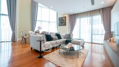 Spacious modern living room with elegant decor and large windows in luxury apartment.