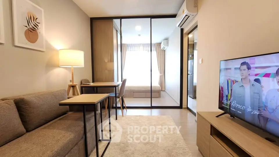 Modern living room with cozy sofa, TV, and stylish decor leading to a bright bedroom.