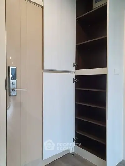 Modern apartment entrance with sleek storage cabinet and digital lock door.
