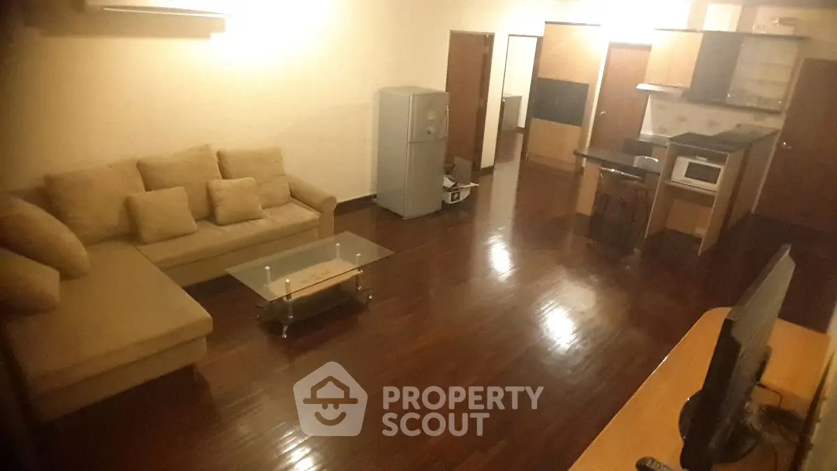 Spacious living room with modern kitchen and cozy sofa in open layout apartment.