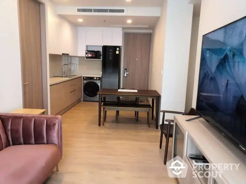 Modern apartment with open layout living room featuring sleek furniture, wooden flooring, and a fully equipped kitchen with state-of-the-art appliances.