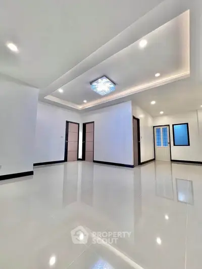 Spacious modern living room with elegant ceiling lighting and glossy floor tiles