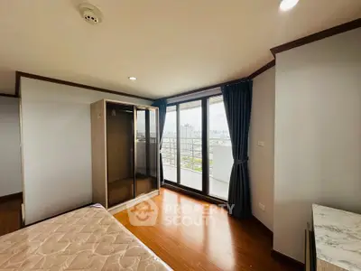 Spacious bedroom with balcony and city view in modern apartment