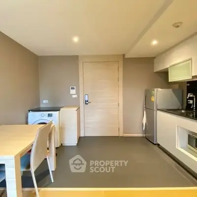 Modern kitchen with sleek appliances and dining area in open layout