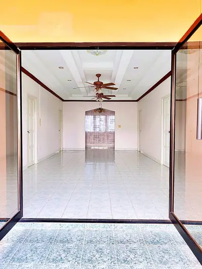 Spacious empty room with ceiling fan and tiled floor, perfect for customization.