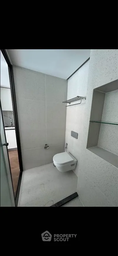 Modern minimalist bathroom with sleek fixtures and neutral tones.