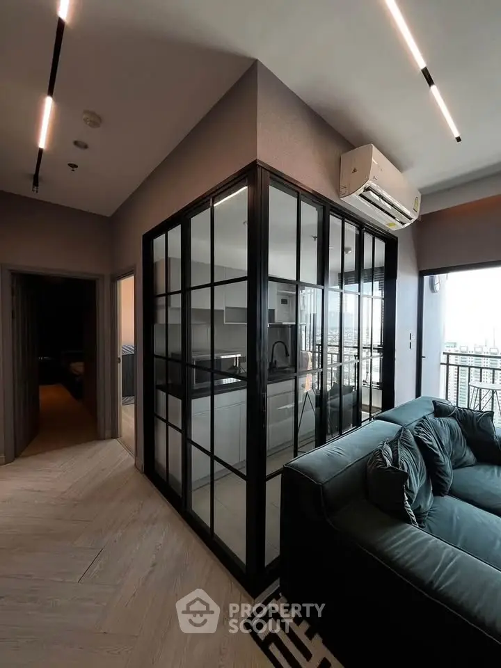 Modern living room with glass-enclosed kitchen and sleek air conditioning unit.