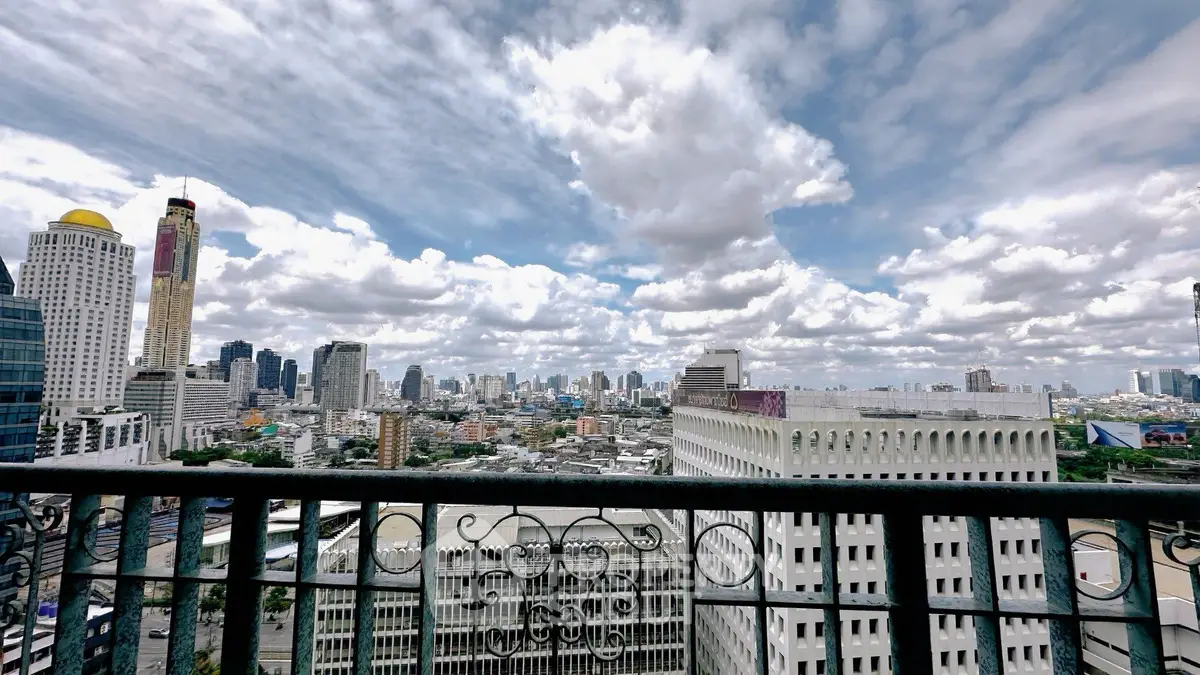 Stunning cityscape view from a high-rise balcony with intricate railing design.