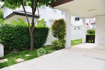 Charming residential exterior with lush greenery and spacious driveway