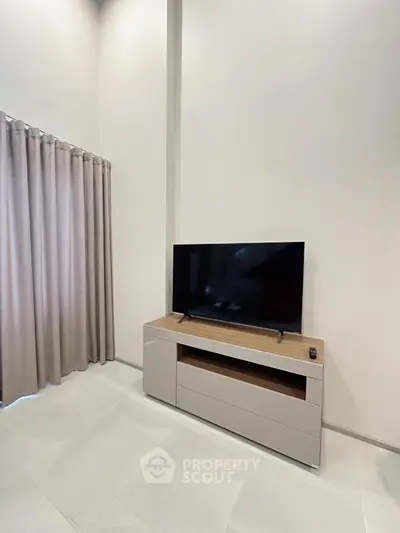 Modern living room with sleek TV stand and elegant curtains, perfect for contemporary home decor.