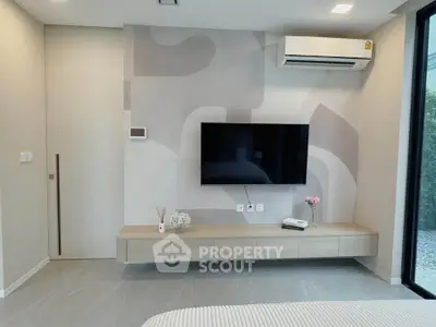 Modern living room with sleek TV setup and air conditioning