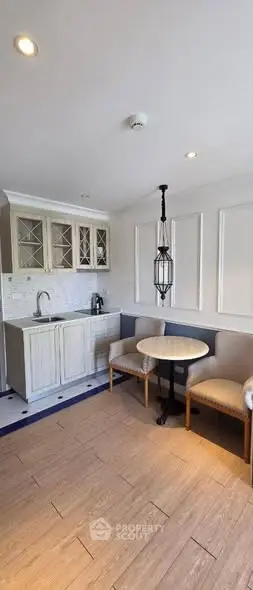 Charming kitchen with cozy dining nook and elegant lighting.