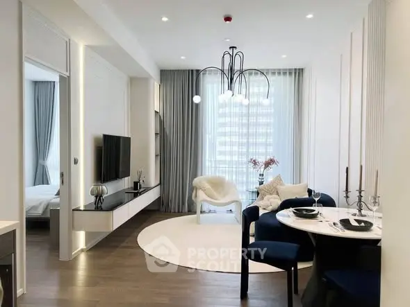 Modern living room with elegant decor and dining area, featuring stylish lighting and large windows.