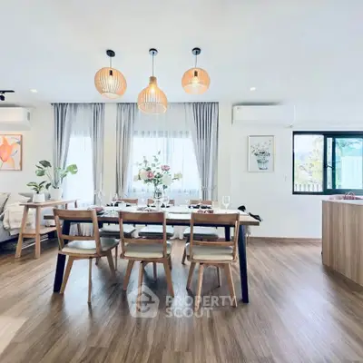 Spacious modern dining area with elegant wooden furniture and stylish lighting, perfect for family gatherings.