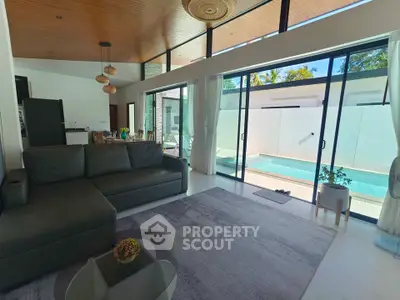 Luxurious living room with pool view, modern decor, and high ceilings in a contemporary home.
