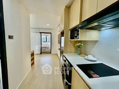 Modern kitchen with sleek appliances and open layout leading to a bright living area.