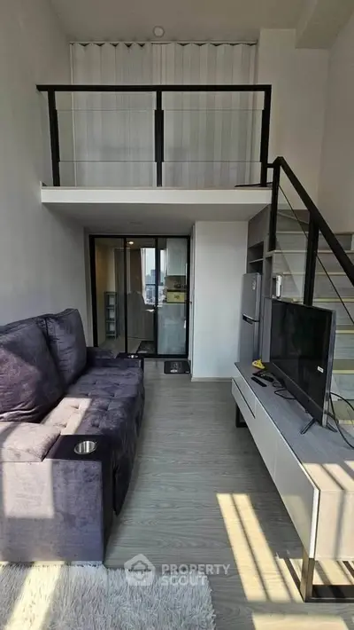 Modern loft apartment with mezzanine, sleek furniture, and natural light.