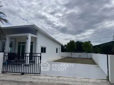 Modern single-story house with spacious driveway and minimalist design, perfect for family living.