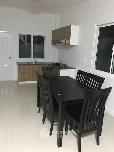 Modern kitchen with sleek black dining set and gas stove in contemporary home