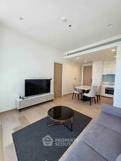 Modern living room with sleek furniture and open kitchen layout in a stylish apartment.