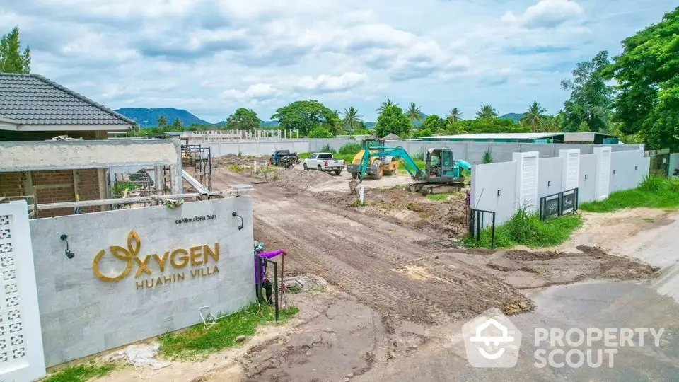 Oxygen Hua Hin Villa construction site with machinery and clear blue sky.