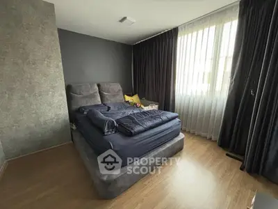 Cozy bedroom with modern decor and large window for natural light.