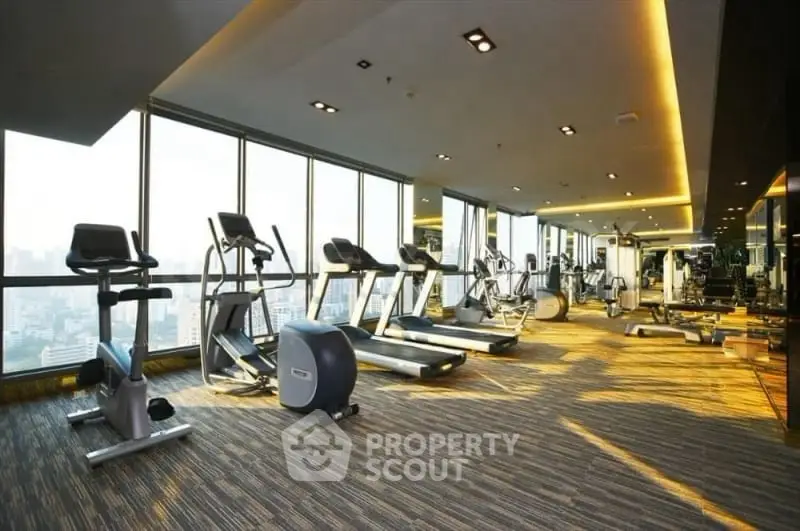 Luxurious high-rise gym with panoramic city views and modern fitness equipment.