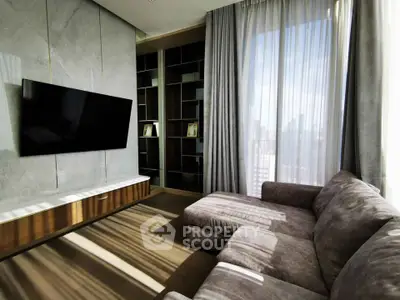 Modern living room with large TV, stylish sofa, and floor-to-ceiling windows offering city views.