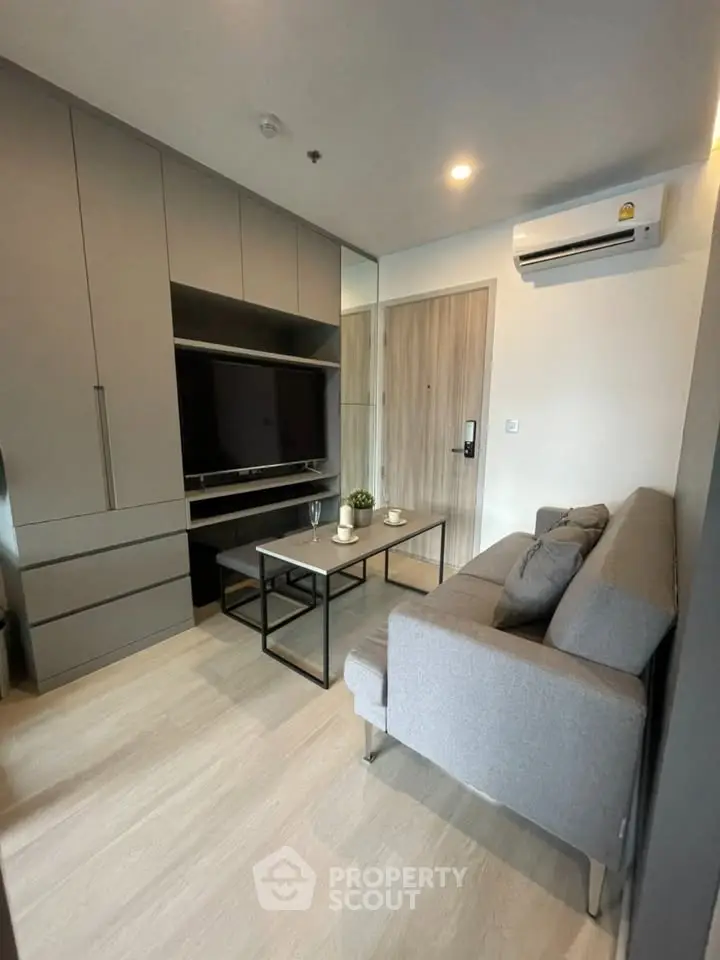 Modern living room with sleek furniture and built-in storage in a cozy apartment.