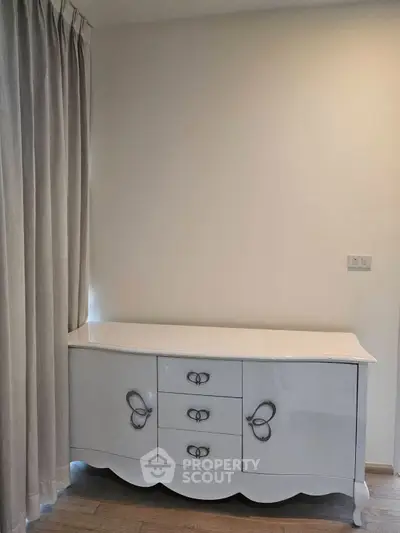 Elegant white dresser in a modern interior with wooden flooring and soft curtains.