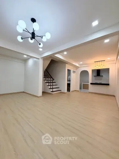 Spacious modern living room with elegant lighting and open kitchen layout