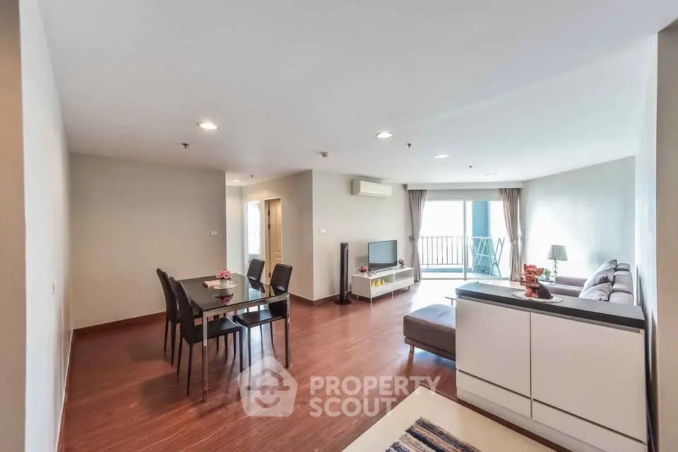 Spacious modern living room with dining area and balcony access in a stylish apartment.