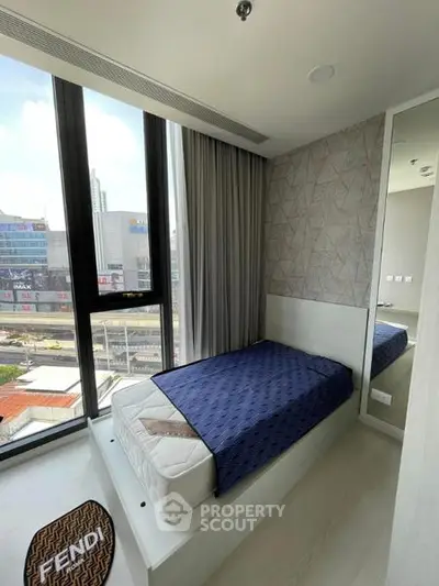 Modern bedroom with floor-to-ceiling windows and city view, featuring a stylish single bed and elegant decor.